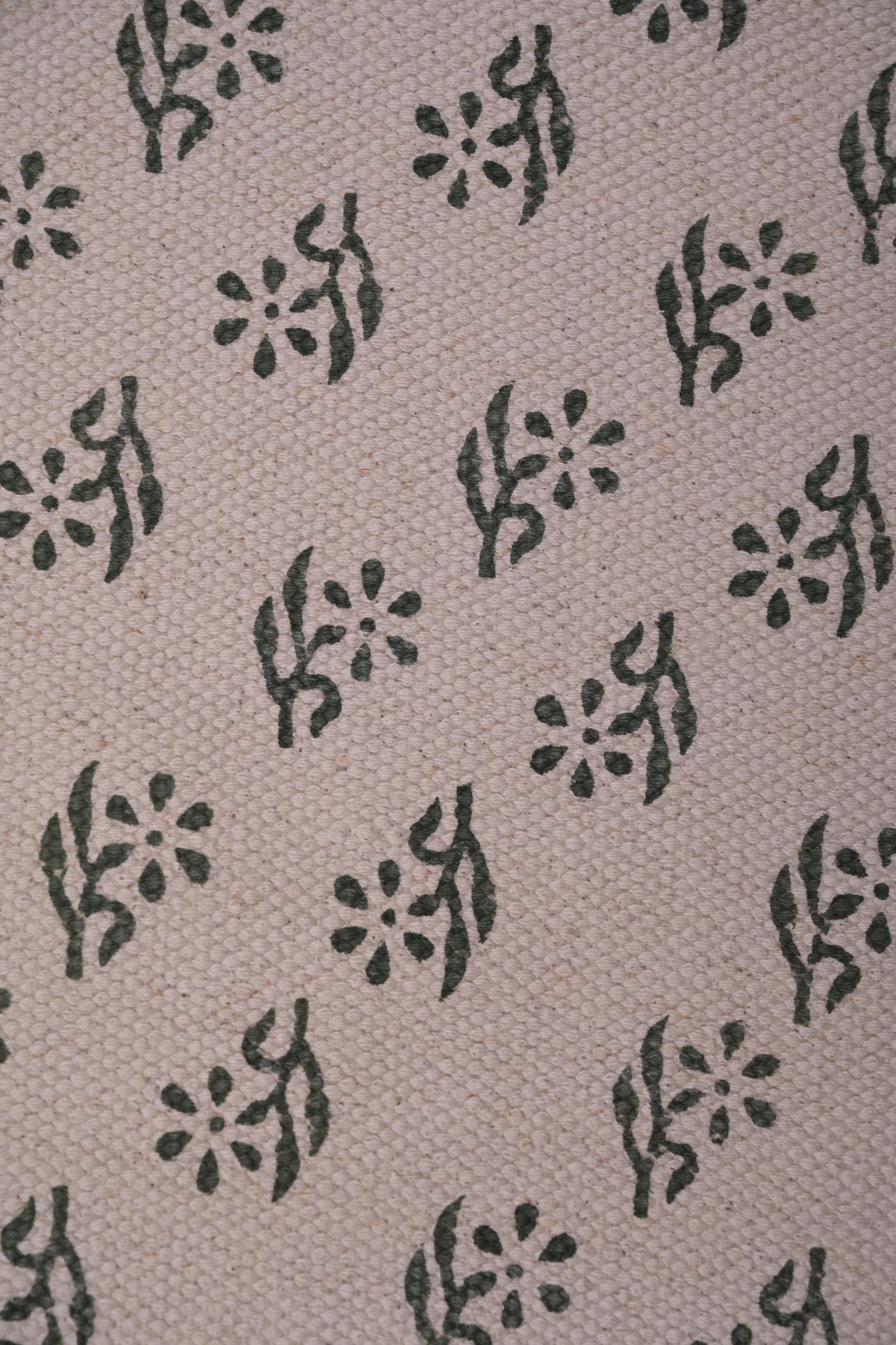 close-up of handwoven cotton runner rug texture with green dot pattern